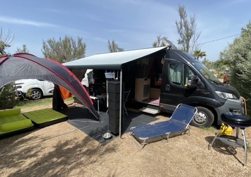 Unser komplett aufgebautes Camp mit unserem Van, ausgefahrener Markise und Pavillon