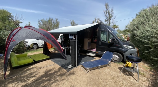 Unser komplett aufgebautes Camp mit unserem Van, ausgefahrener Markise und Pavillon